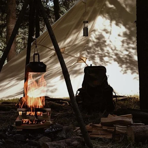 Natural cotton canvas tarp providing shelter beside a campfire