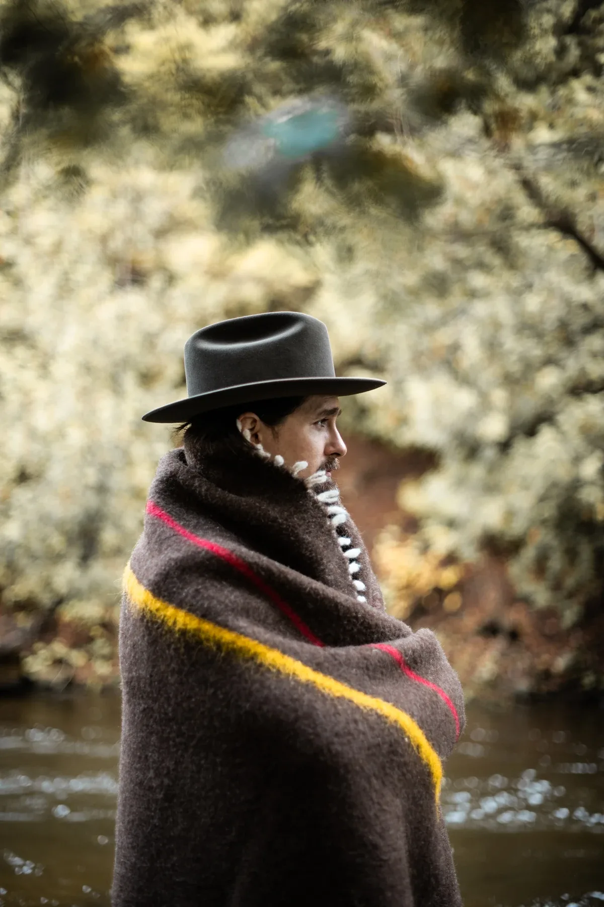 Wrapped in a natural wool blanket beside the river