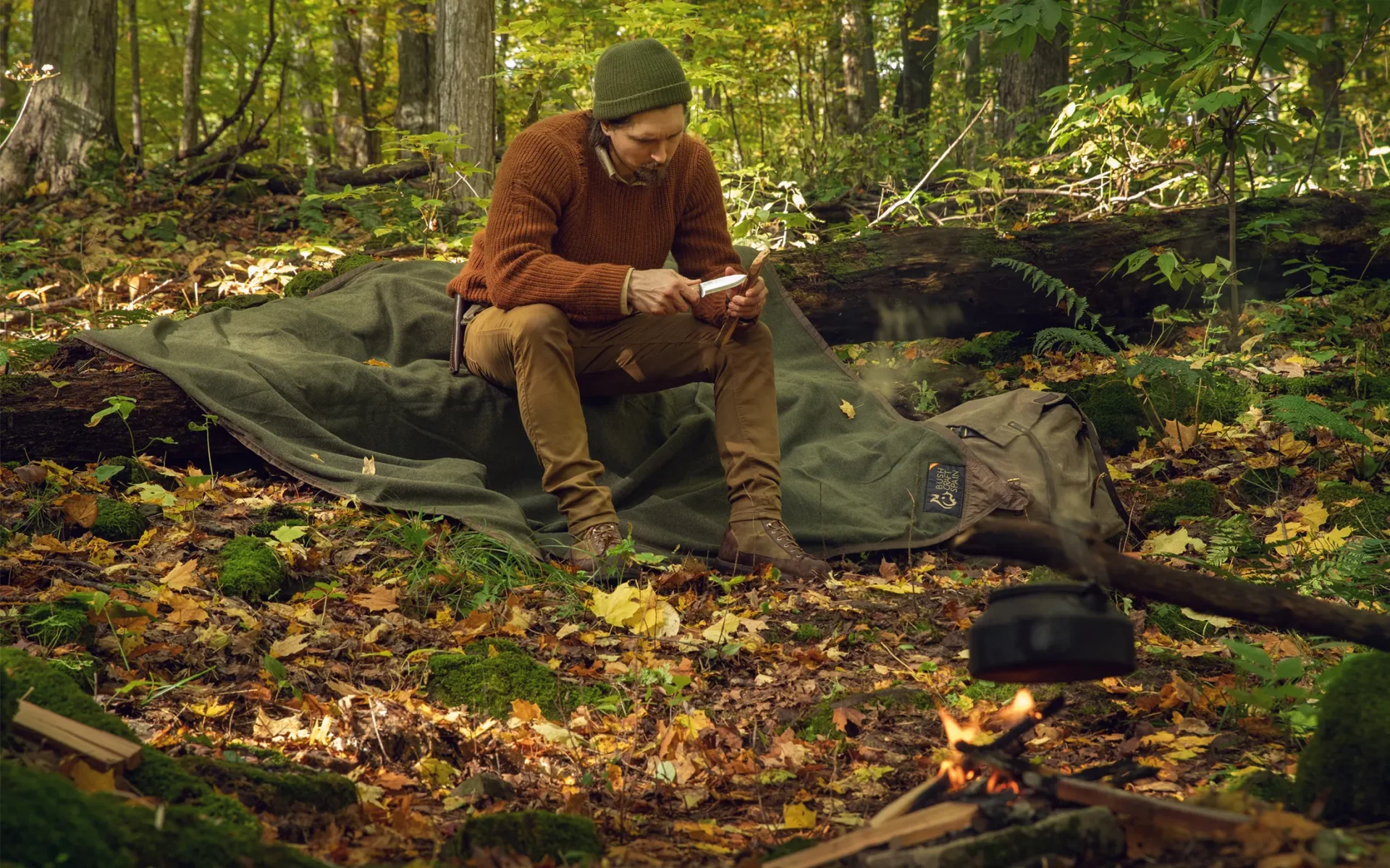 Trustin Timber working beside the campfire on a Bushcraft Spain ground cloth