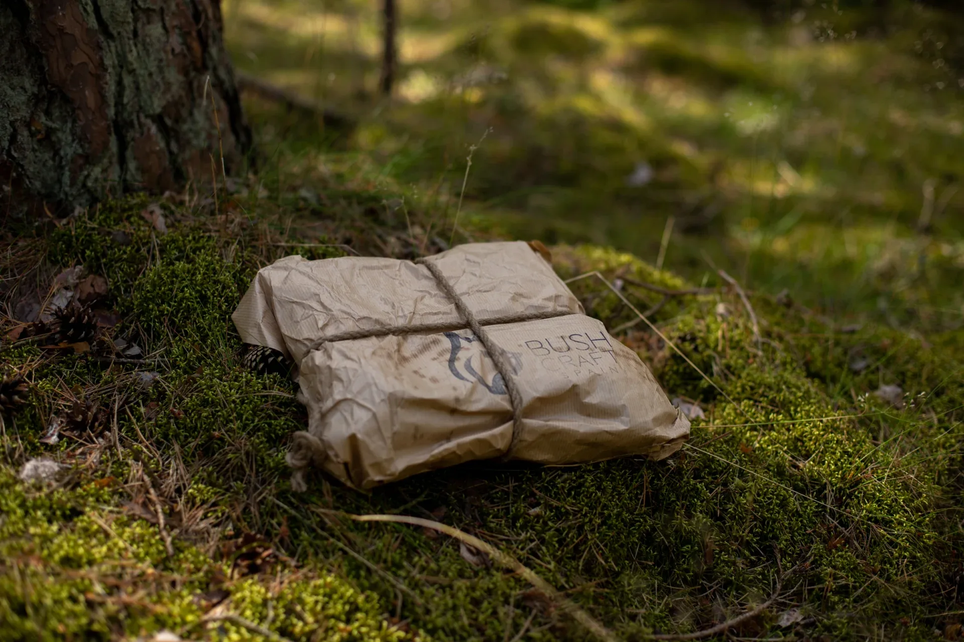 Bushcraft Spain package wrapped in paper and tied with twine in the forest