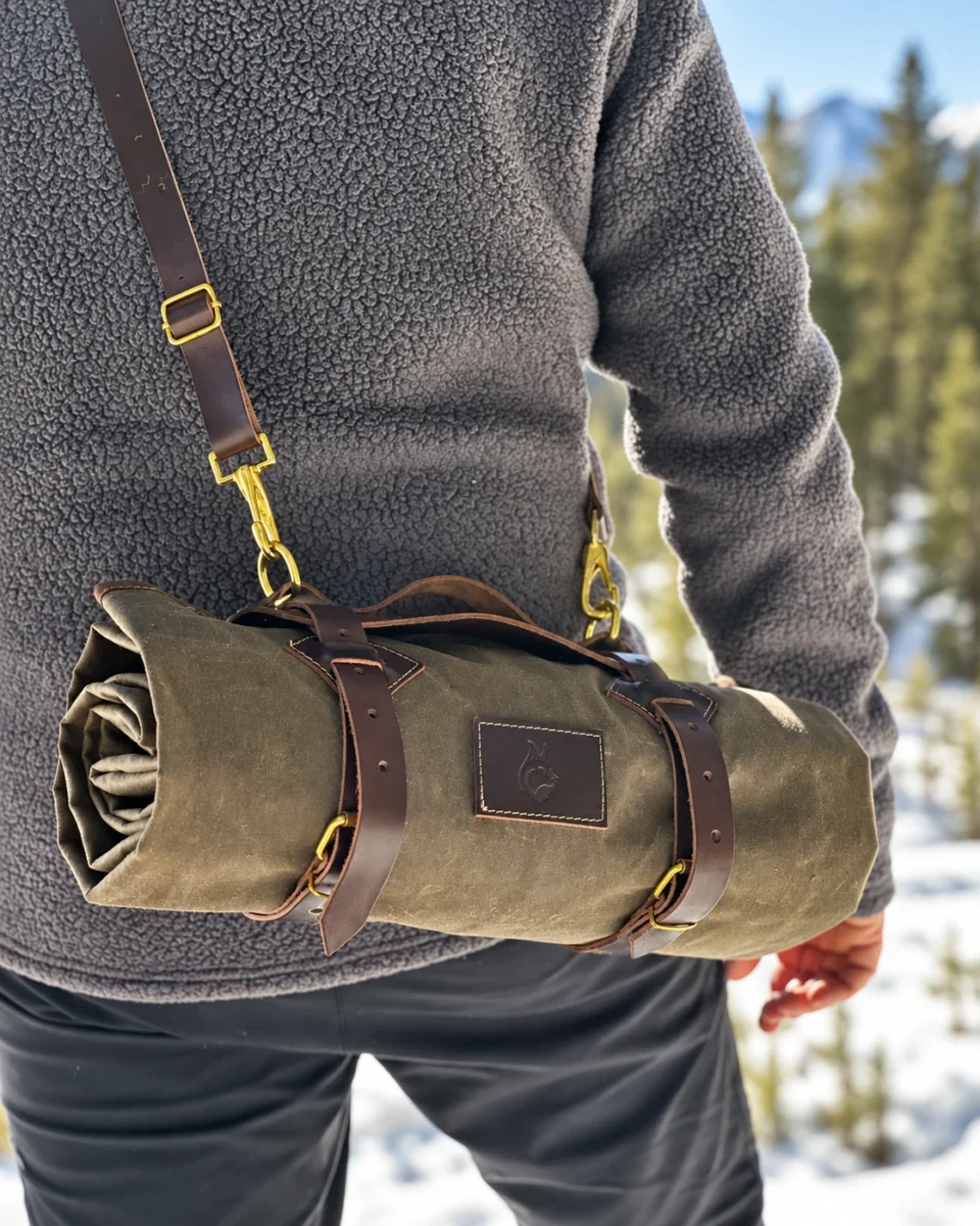 Compact oilskin roll carried with leather straps across the shoulder