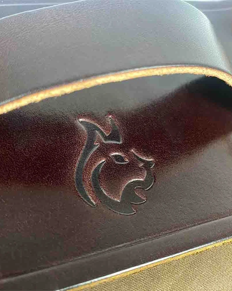 Bushcraft Spain-Emblem auf dem braunen Lederträger geprägt