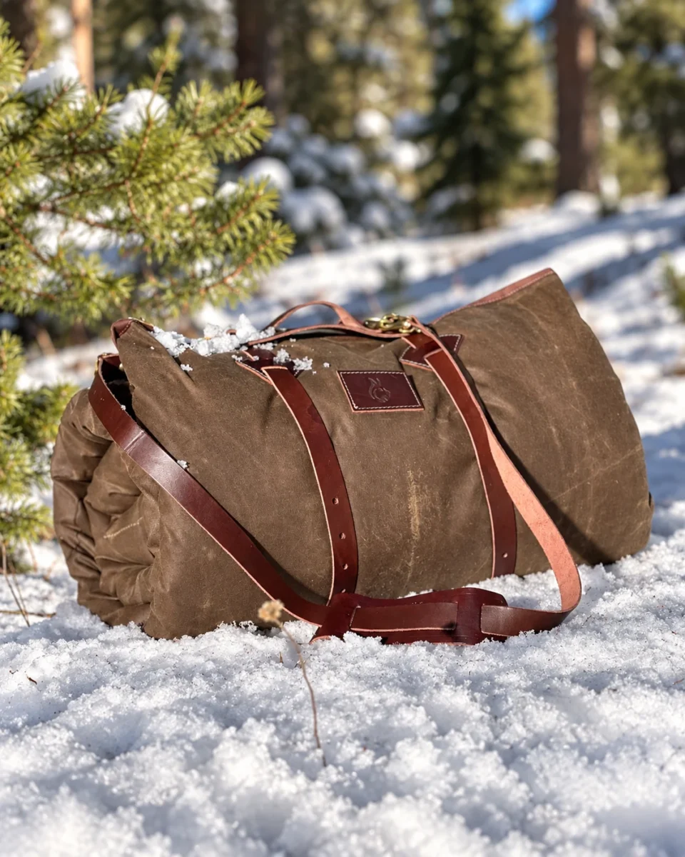 Leather Carrier securing a large oilskin bedroll with shoulder strap in the snow