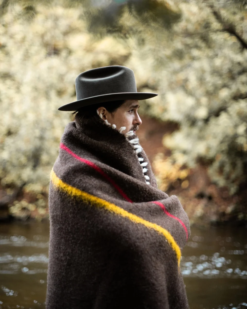 Brown merino wool blanket worn beside a woodland stream