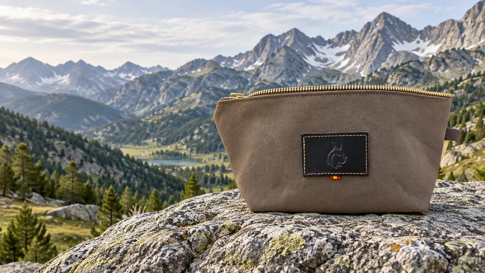Brown 14 oz dry waxed canvas travel bag on a rock overlooking an alpine lake and mountains