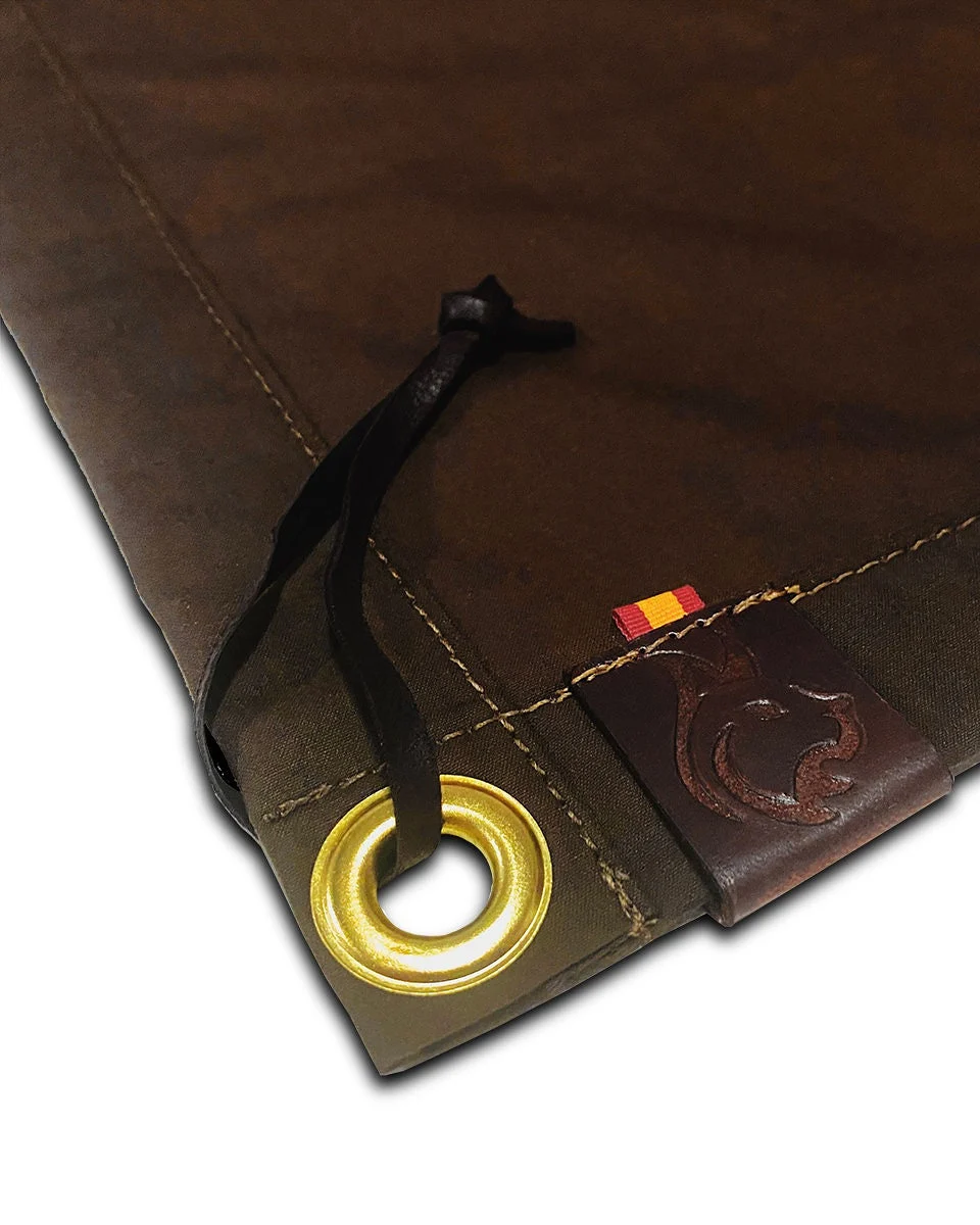 Brass grommet, stitching and leather label on an oilskin mat