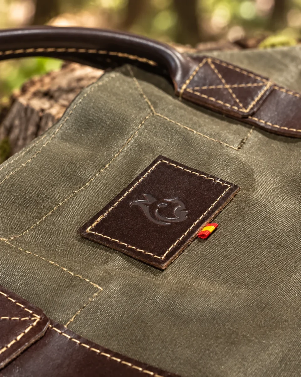 Leather logo patch and reinforced stitching on the oilskin log carrier