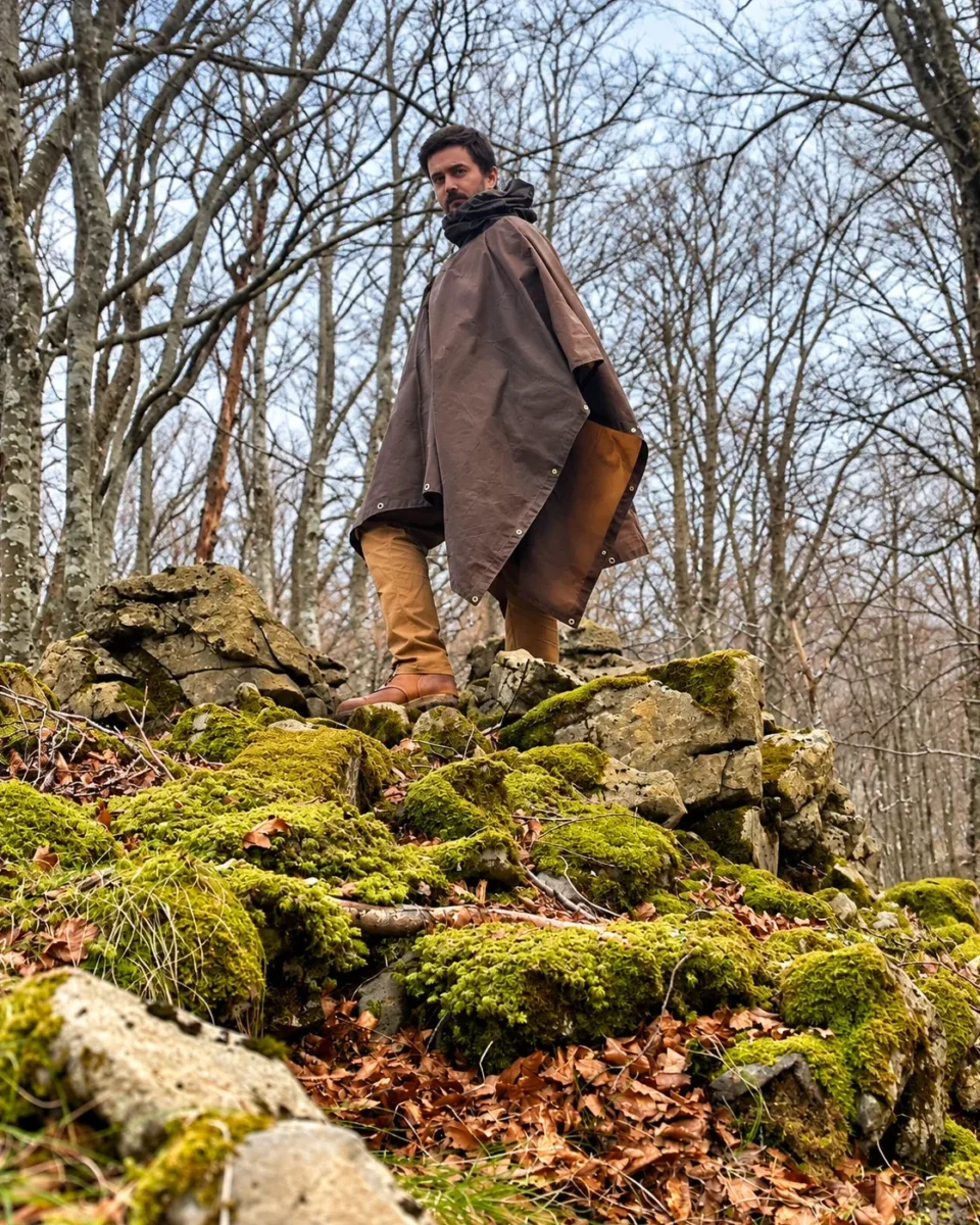 Brown Oilskin Poncho Shelter worn on moss-covered rocks in woodland