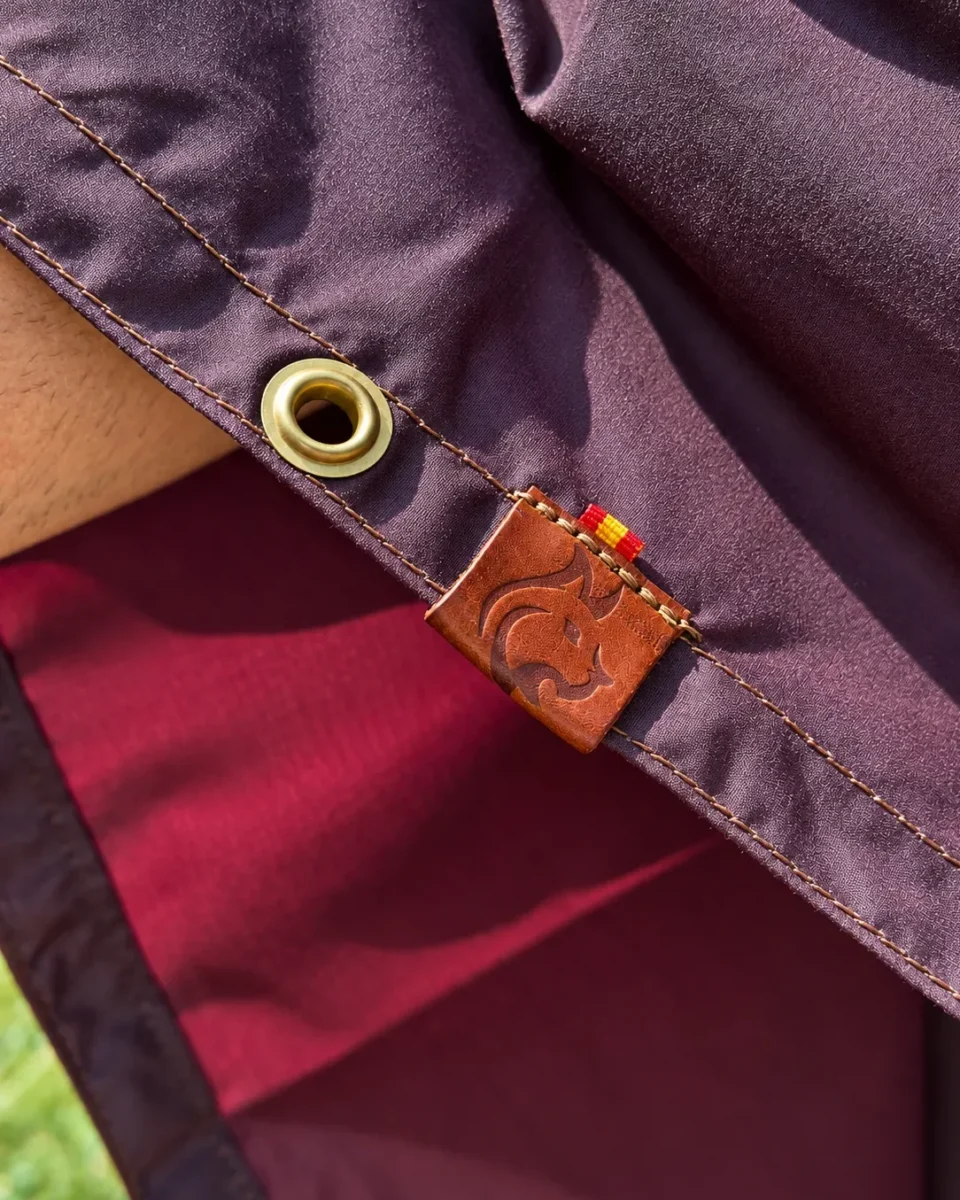 Burgundy Oilskin Poncho Shelter with brass eyelet, stitched hem and Bushcraft Spain leather label