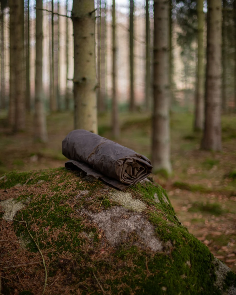 Rolled oilskin and wool ground cloth on a mossy rock