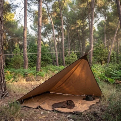 Survival oilskin tarp pitched as a compact woodland shelter